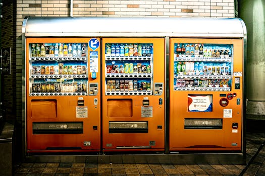 Eye-catching orange vending machines offer a variety of drinks indoors, illuminated brightly.